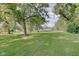 Landscaped backyard with inground pool, pond and trees at 3621 Olive Branch Rd, Greenwood, IN 46143