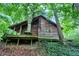 Rustic log cabin with a wooden deck and forest backdrop at 9307 E Dill Rd, Morgantown, IN 46160