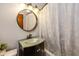 Clean bathroom with a round mirror and updated vanity at 975 Rolling Hill Rd, Greenwood, IN 46142