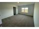 Bright bedroom with neutral carpeting and a window overlooking the yard at 6229 Card Blvd, Indianapolis, IN 46221