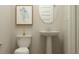 Small bathroom with pedestal sink, toilet, and framed print at 11738 Aubrey Ln, Fishers, IN 46040