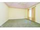 Bright bedroom with yellow walls, green carpet, and a window with patterned curtains at 8358 Hidden Point Dr, Indianapolis, IN 46256