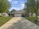 Brick ranch home with 2-car garage and landscaped yard at 10673 Medinah Dr, Indianapolis, IN 46234