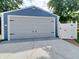 Detached garage with a new gray door and blue siding at 32 E Caven St, Indianapolis, IN 46225