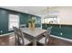 Elegant dining room with gray table, dark hardwood floors and green accent wall at 5746 Ralston Ave, Indianapolis, IN 46220