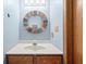 Updated bathroom with wood vanity, single sink, and round mirror at 1936 Broadmoor Ln, Columbus, IN 47203