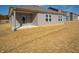 Rear view of a ranch style home with gray siding, covered patio, and a small yard at 6205 Card Blvd, Indianapolis, IN 46221