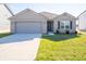 Brick ranch home with gray garage door and landscaped lawn at 6205 Card Blvd, Indianapolis, IN 46221