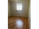 Simple bedroom with light walls, wood-look flooring, and a window with curtains at 2416 Radcliffe Ave, Indianapolis, IN 46227