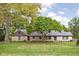 Ranch home with stone facade and mature trees at 7201 N Illinois St, Indianapolis, IN 46260