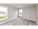 Empty bedroom with neutral gray walls, plush carpeting, and large windows offering ample natural light at 1098 Gatewick Ct, Greenwood, IN 46143