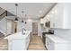 Sleek kitchen boasts white cabinets, quartz countertops, a large island with sink, and stainless steel appliances at 1098 Gatewick Ct, Greenwood, IN 46143