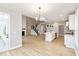 Open-concept living area with wood floors, a staircase with black railing, and a view into the kitchen at 1098 Gatewick Ct, Greenwood, IN 46143