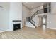 Living room with a fireplace, staircase with black railing, and view of the entryway at 1098 Gatewick Ct, Greenwood, IN 46143