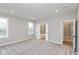 Main bedroom with gray walls, plush carpet, and open doors leading to an ensuite bathroom at 1098 Gatewick Ct, Greenwood, IN 46143