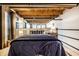 Main bedroom with a double bed, exposed beams, and a partial loft view at 735 Lexington Ave # Apt 8, Indianapolis, IN 46203
