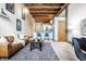 Open living area with exposed beams, leather sofa, and a modern aesthetic at 735 Lexington Ave # Apt 8, Indianapolis, IN 46203