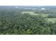 Aerial view showing property's wooded surroundings and a large open field at 4463 W 700 S, Trafalgar, IN 46181