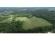 Aerial view of property, showcasing a large field surrounded by trees and homes at 4463 W 700 S, Trafalgar, IN 46181