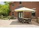 Relaxing patio area with outdoor dining set and yellow striped umbrella at 8011 Morningside Dr, Indianapolis, IN 46240