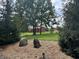 Landscaped yard with two unique stone features and a red barn in the background at 7601 S 700 W, Morgantown, IN 46160