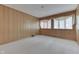 Bedroom with wood paneled walls and carpeted floor, and two windows at 7601 S 700 W, Morgantown, IN 46160