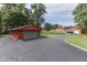 Red garage with gray door and spacious asphalt driveway at 7601 S 700 W, Morgantown, IN 46160