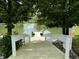 White wooden dock extending over a calm pond, ideal for fishing or relaxation at 7601 S 700 W, Morgantown, IN 46160