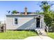 Rear view of a small beige house with a small porch, steps, and fenced yard at 21 E Hanna Ave, Indianapolis, IN 46227