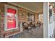 Inviting front porch with wicker seating and a red door at 303 Wellington Overlook, Noblesville, IN 46060
