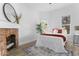 Bright bedroom featuring a fireplace, hardwood floors, and a comfortable bed at 1046 Dawson St, Indianapolis, IN 46203