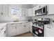 White kitchen with stainless steel appliances and a large window at 1046 Dawson St, Indianapolis, IN 46203