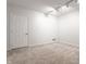 Empty basement room with neutral walls, carpet, and a door at 571 Lockerbie S Cir, Indianapolis, IN 46202
