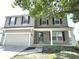 Two-story house with beige siding, black shutters, and a two-car garage at 6558 Caressa Way, Indianapolis, IN 46259