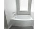 Modern bathroom featuring a corner bathtub and gray vinyl flooring at 6558 Caressa Way, Indianapolis, IN 46259