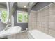 Updated bathroom with a pedestal sink, bathtub, and large window at 307 Berkley Rd, Indianapolis, IN 46208