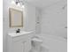 Clean bathroom with white vanity, bathtub, and marble-style shower surround at 248 N Walcott N St, Indianapolis, IN 46201