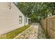 Gravel driveway and fenced side yard with mature trees at 3649 N Sadlier Dr, Indianapolis, IN 46226