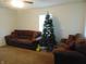 Spacious living room with brown couches and a Christmas tree at 359 N Pearl St, Thorntown, IN 46071