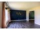 Living room featuring dark vinyl flooring, a blue accent wall, and a patterned accent wall at 8233 Warbler Way, Indianapolis, IN 46256