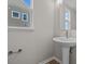 Clean bathroom with pedestal sink, mirror and wood-look flooring at 4988 Amber Crest Dr, Brownsburg, IN 46112