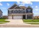 Two-story home with gray siding, white trim, and a three-car garage at 4988 Amber Crest Dr, Brownsburg, IN 46112