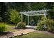White pergola with hanging chairs nestled in a garden setting at 12980 W Mt. Healthy Rd, Columbus, IN 47201