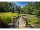 Wooden footbridge leading through a beautifully landscaped garden at 12980 W Mt. Healthy Rd, Columbus, IN 47201