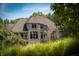 Stone house exterior partially seen through trees and grass at 12980 W Mt. Healthy Rd, Columbus, IN 47201