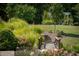 Landscaped backyard with a bridge and seating area under a pergola at 12980 W Mt. Healthy Rd, Columbus, IN 47201