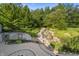 Landscaped backyard with a charming stream and stone retaining walls at 12980 W Mt. Healthy Rd, Columbus, IN 47201