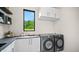 Modern laundry room with dark gray washer and dryer and quartz countertop at 1248 Chatham Rdg Ct, Westfield, IN 46074