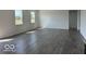 Spacious living room featuring wood-look flooring and large windows at 140 Hobbs Dr, Whiteland, IN 46184