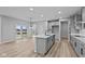 Open concept kitchen with gray cabinets, island, and access to backyard patio at 4959 Amber Crest Dr, Brownsburg, IN 46112